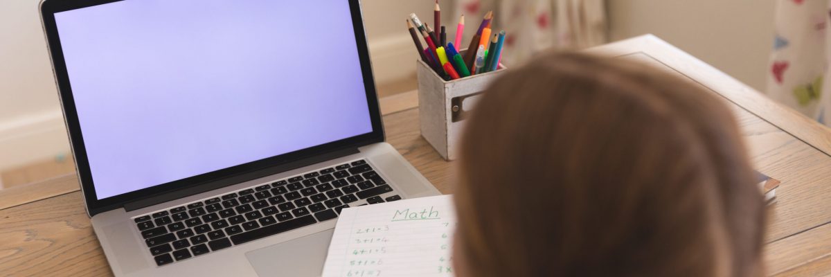 Caucasian girl having video call during class on laptop with copy space, sitting at desk at home. online schooling, distance learning and education at home.